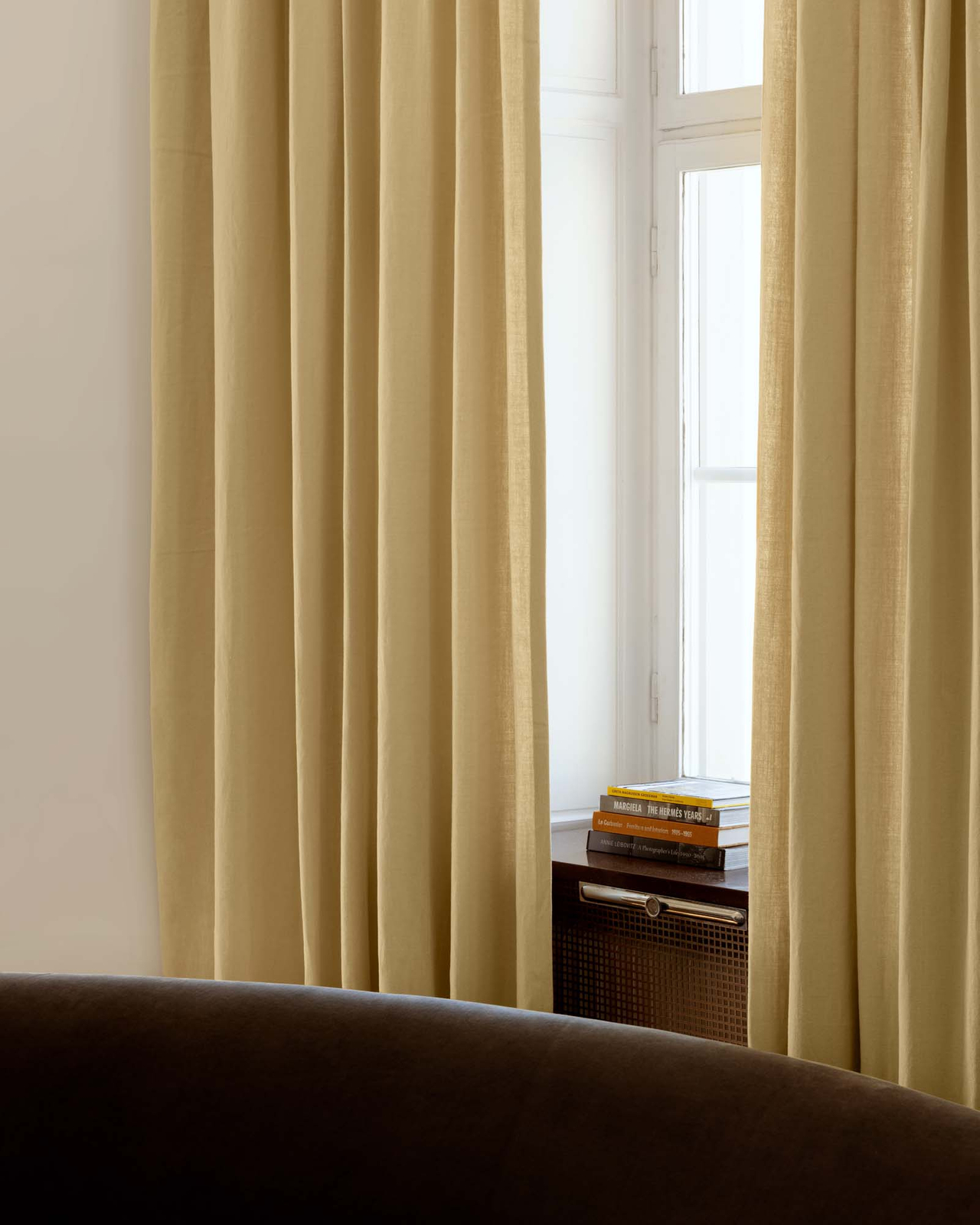 The Studio Linen curtain in Sunrise, styled in a room showing its heavyweight linen weave and soft vertical folds.
