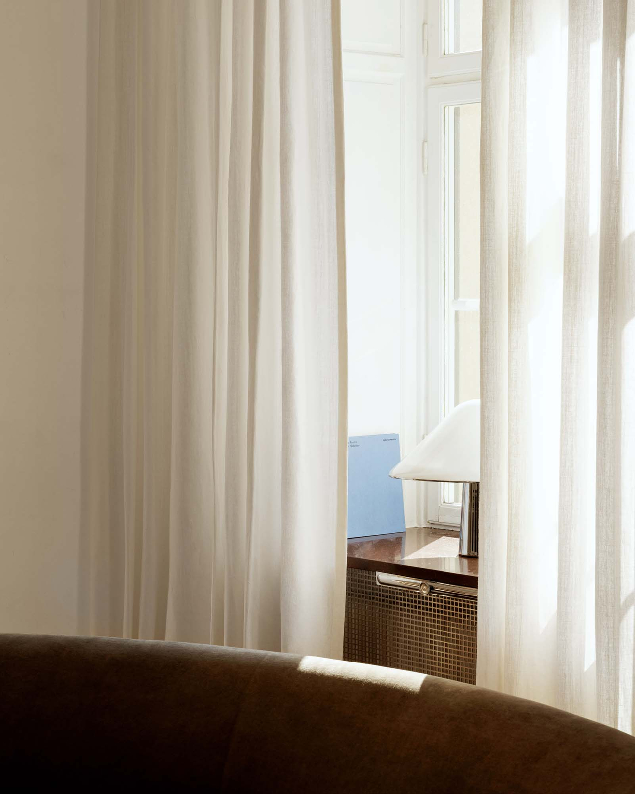 The Studio Linen curtain in White, featuring its luminous texture and soft, natural drape, styled in a room setting.