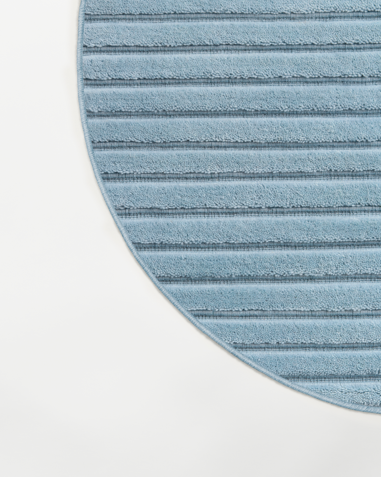 Close-up of the Park 02 - Sky - Custom US Size rug, showing its soft blue plush pile and linear texture with a curved edge.