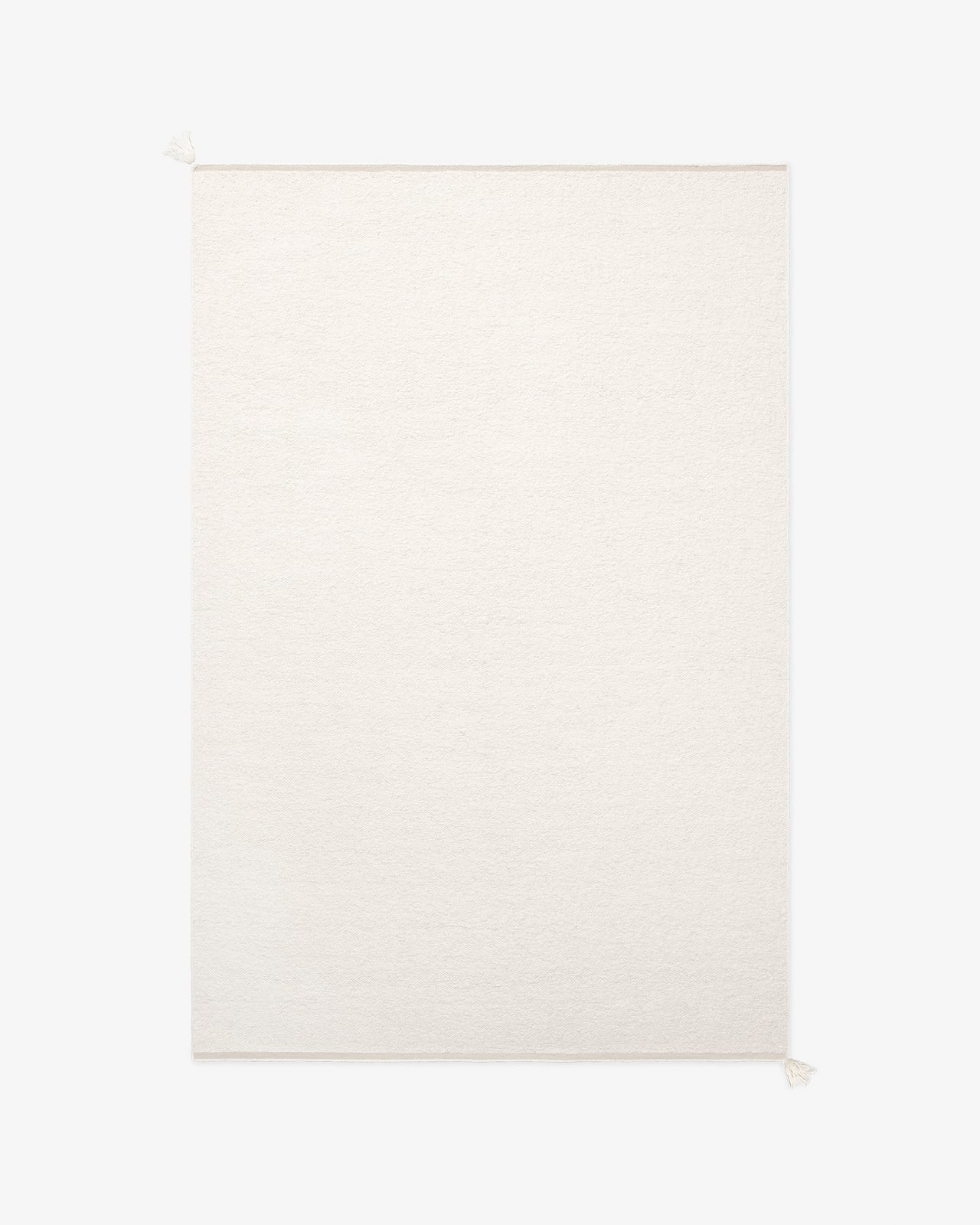 Boucle i Cream — en handvävd ullmatta i en varm krämvit ton med en rik, strukturerad bouclévävd yta.