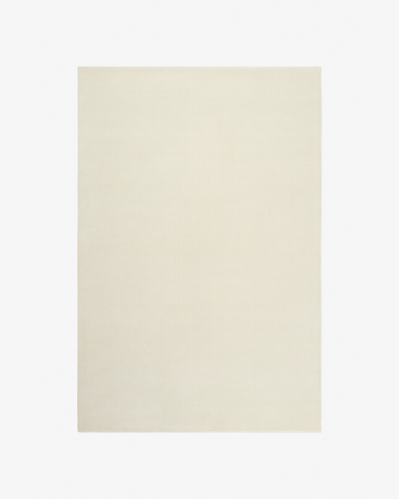 Grand i Dusty White — en mjuk ullmatta i en varm benvit ton med slät yta och tät lugg.