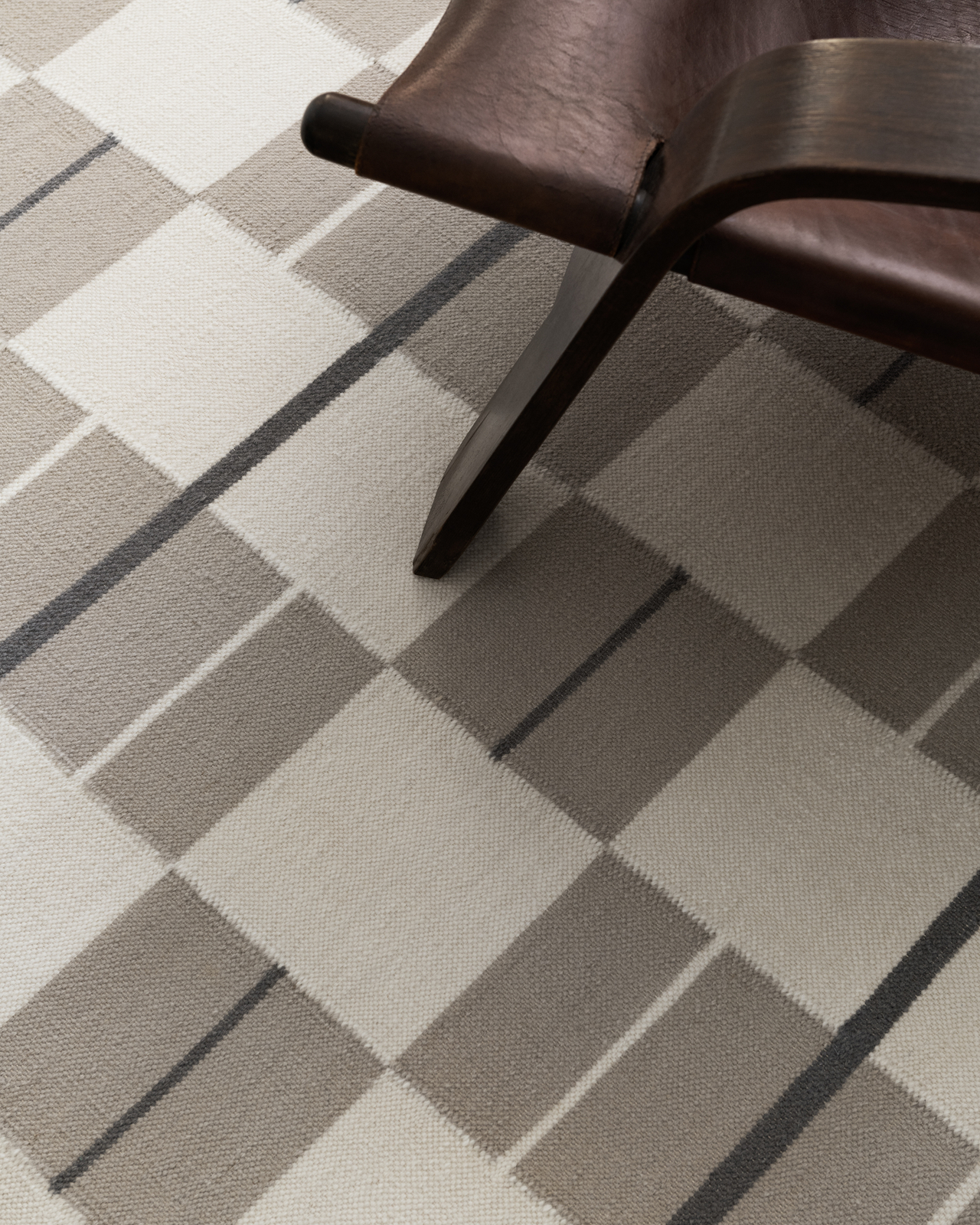 Båstad hand-woven flatweave rug in Cream, featuring a checkered pattern in cream and taupe with thin horizontal lines.
